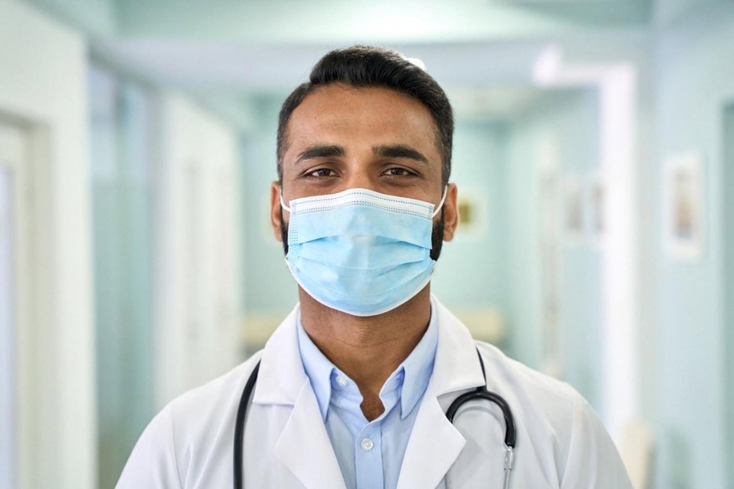 Young male dentist in a UAE clinic wearing a surgical mask and white coat